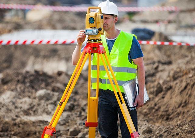 Geodeta robi pomiar pod budowę